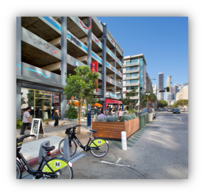 Image of sidewalk, bike racks, planter and parklet on a downtown street